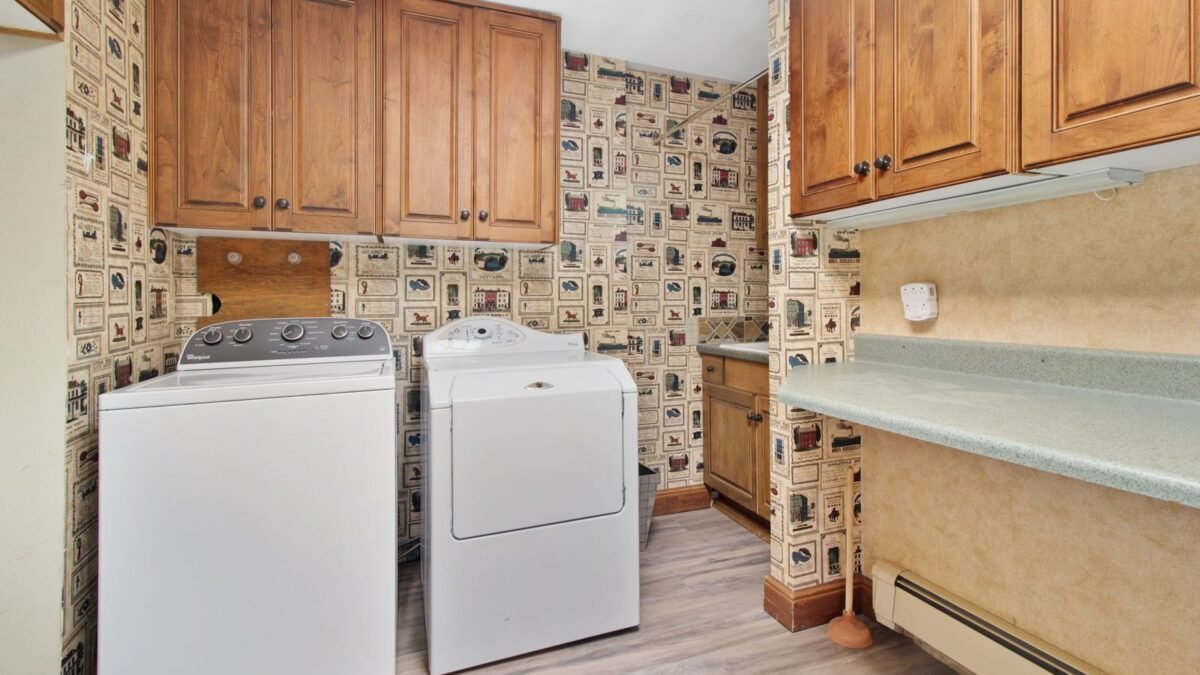 Cozy laundry room with wooden cabinets, washer, and dryer setup, illustrating best 40000 grain water softener