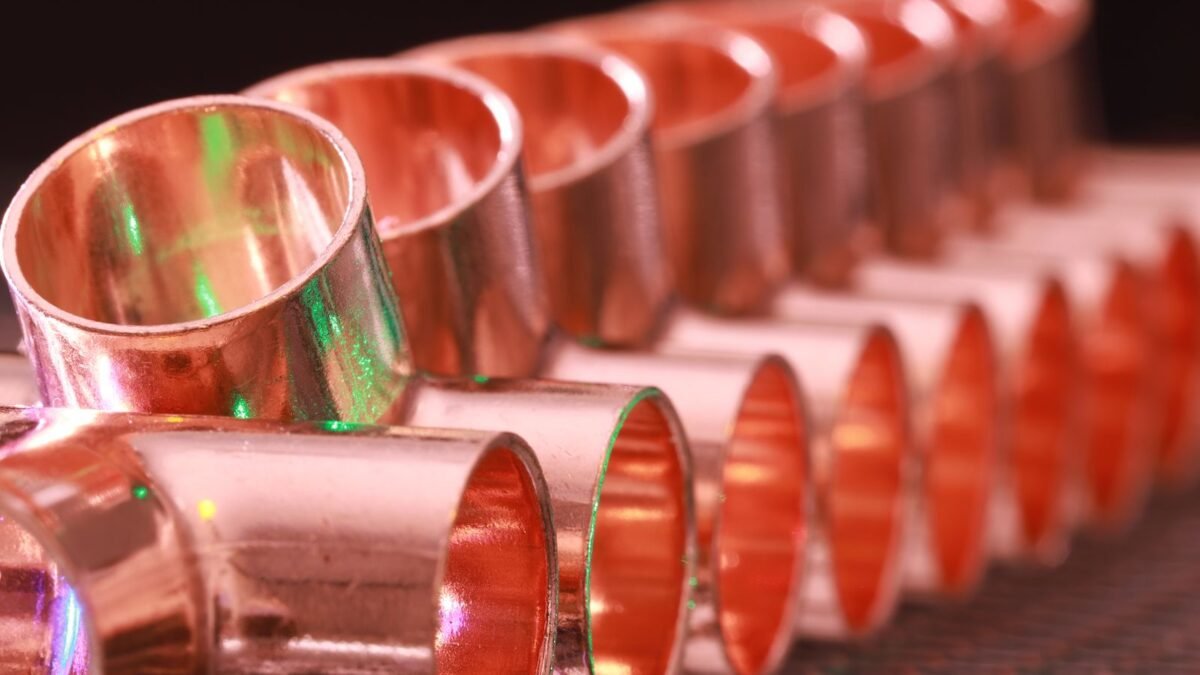 Copper plumbing fittings arranged in a row, showcasing metallic texture and industrial detail, illustrating best 48000 grain water softener