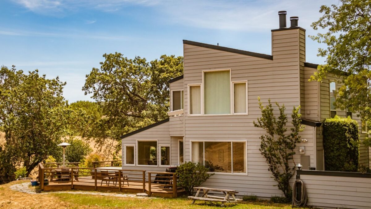 Contemporary suburban house featuring large glass windows and a spacious deck in a lush outdoor, illustrating best 80000 grain water softener