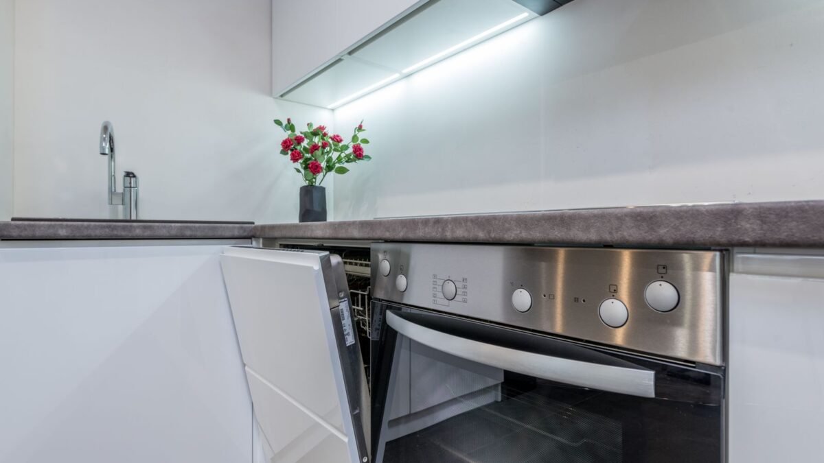 Sleek kitchen interior featuring an open dishwasher and vibrant flowers on the counter, illustrating best dishwasher cleaner
