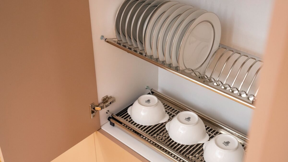 A clean and organized kitchen cabinet displaying plates and bowls on a drying rack, illustrating best dishwasher salt