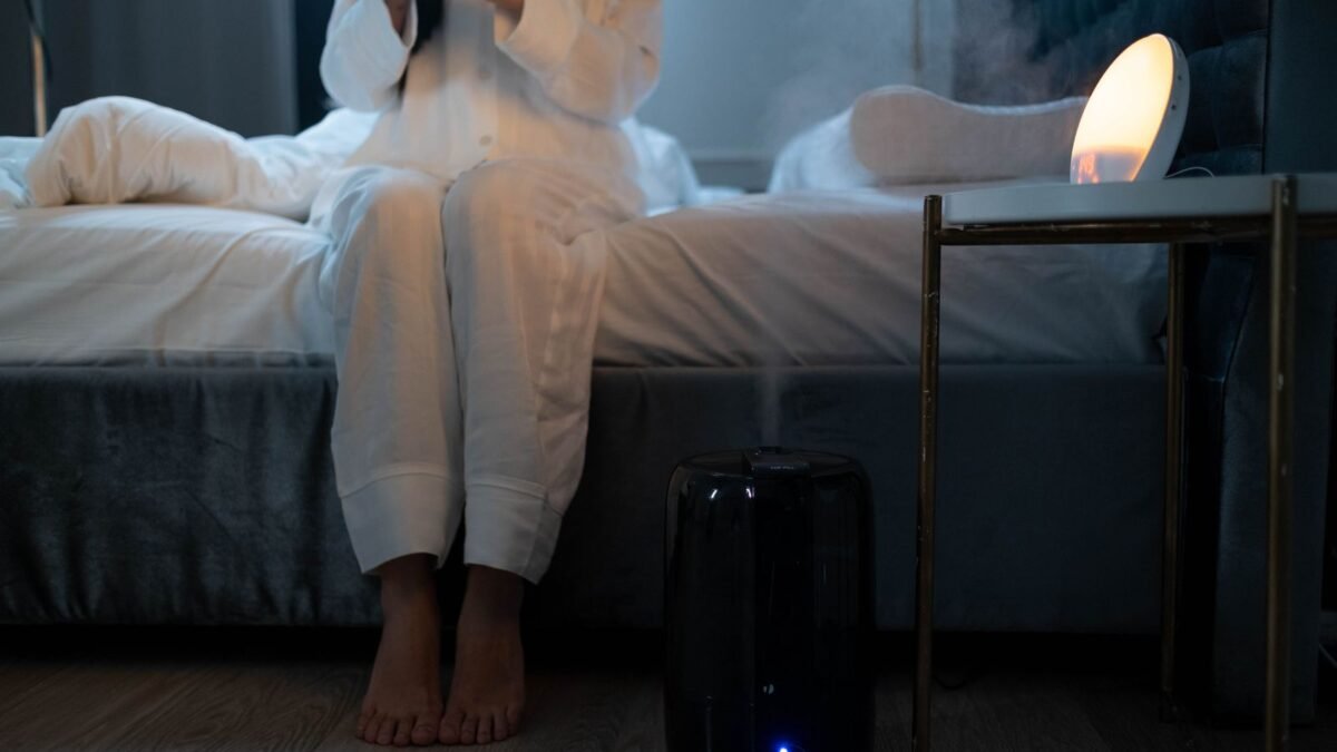 A serene bedroom scene with humidifier mist illuminating soft lighting, creating a calm atmosph, illustrating best humidifier for hard water