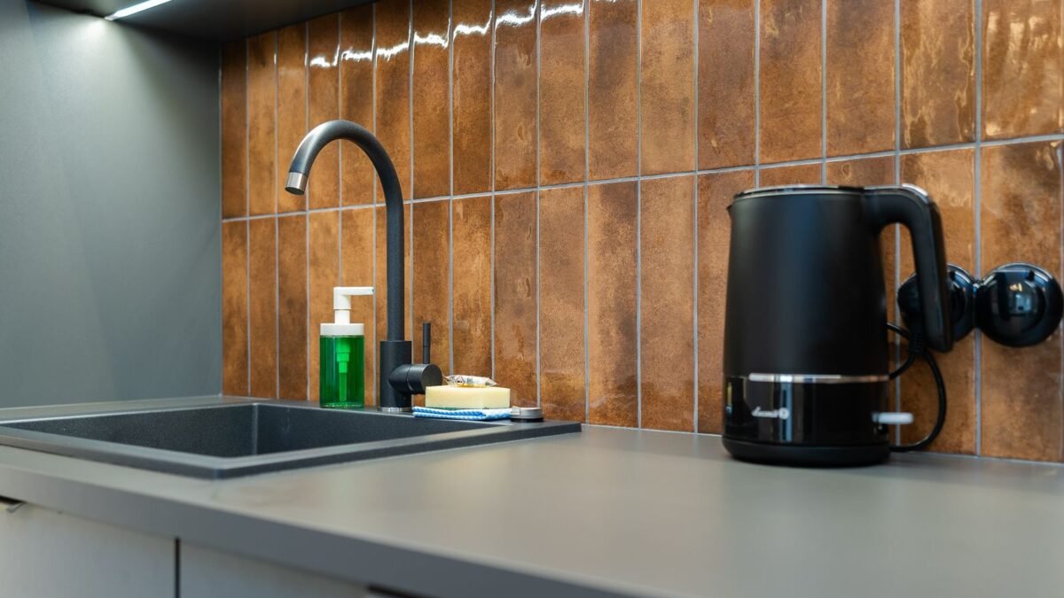 Contemporary kitchen counter setup with a sink, soap dispenser, and electric kettle, illustrating best kettle descaler