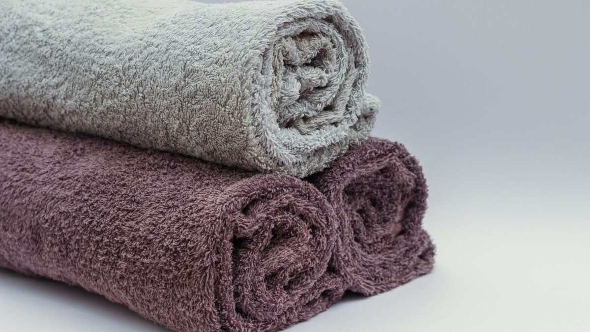 Close-up of rolled bathroom towels in neutral tones, ideal for interior design or spa themes, illustrating best laundry water softener additive