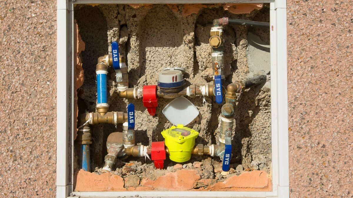Detailed view of a complex water meter setup embedded in a concrete wall, illustrating best non electric water softener