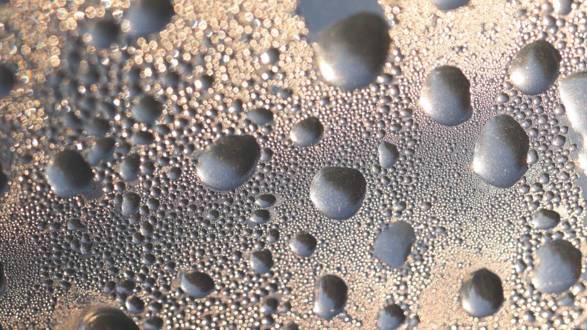 Artistic macro shot capturing water droplets condensed on a glass surface, creating a unique te, illustrating best water distiller