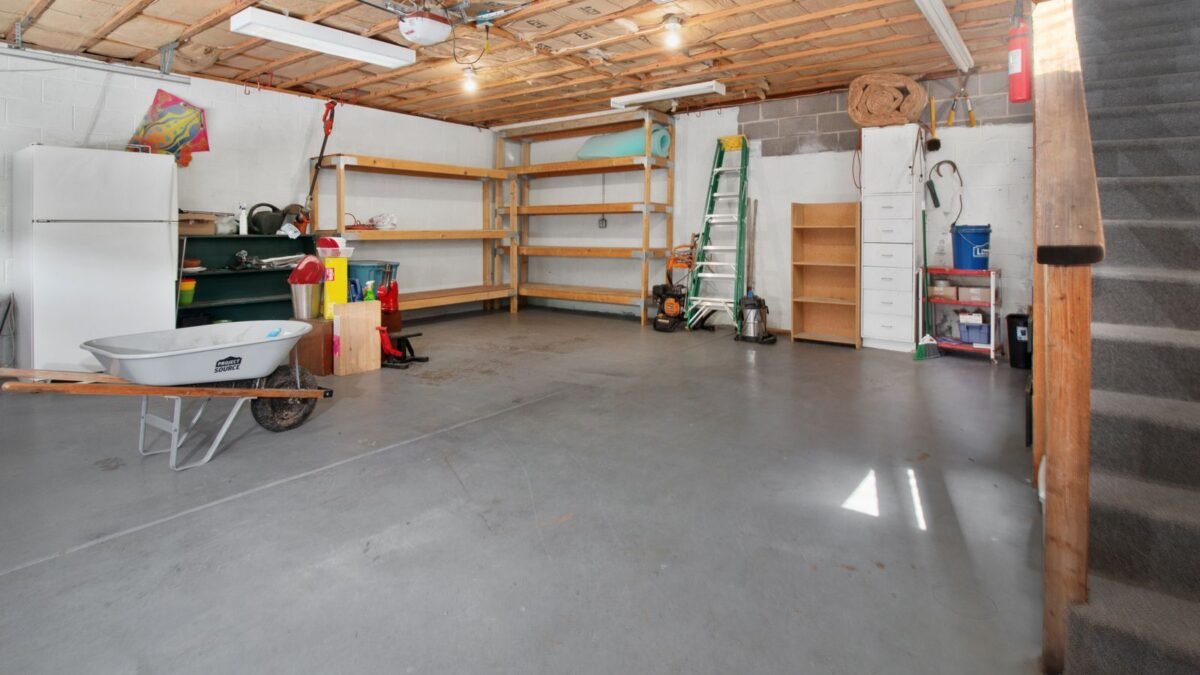 Spacious garage interior with storage shelves, tools, and a wheelbarrow, ideal for home organiz, illustrating best water softener enclosure