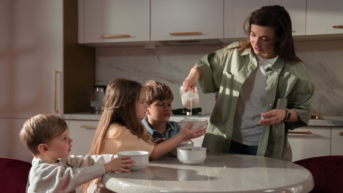 Family of four in a kitchen, the household a whole house water softener is sized for