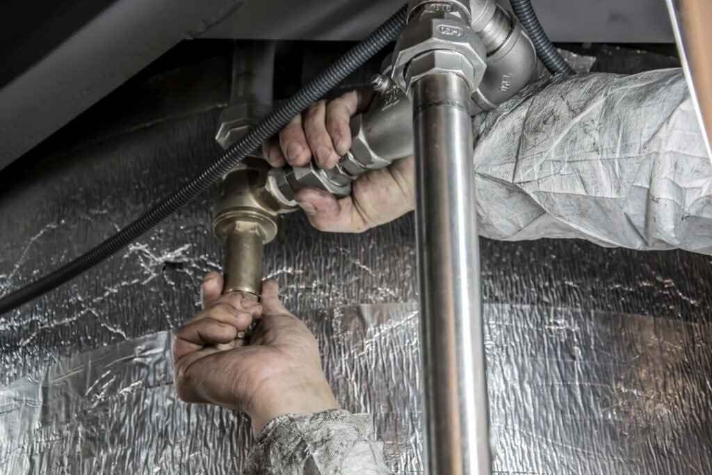 Plumber fitting a valve on a main water line, the same job as installing a whole house water softener