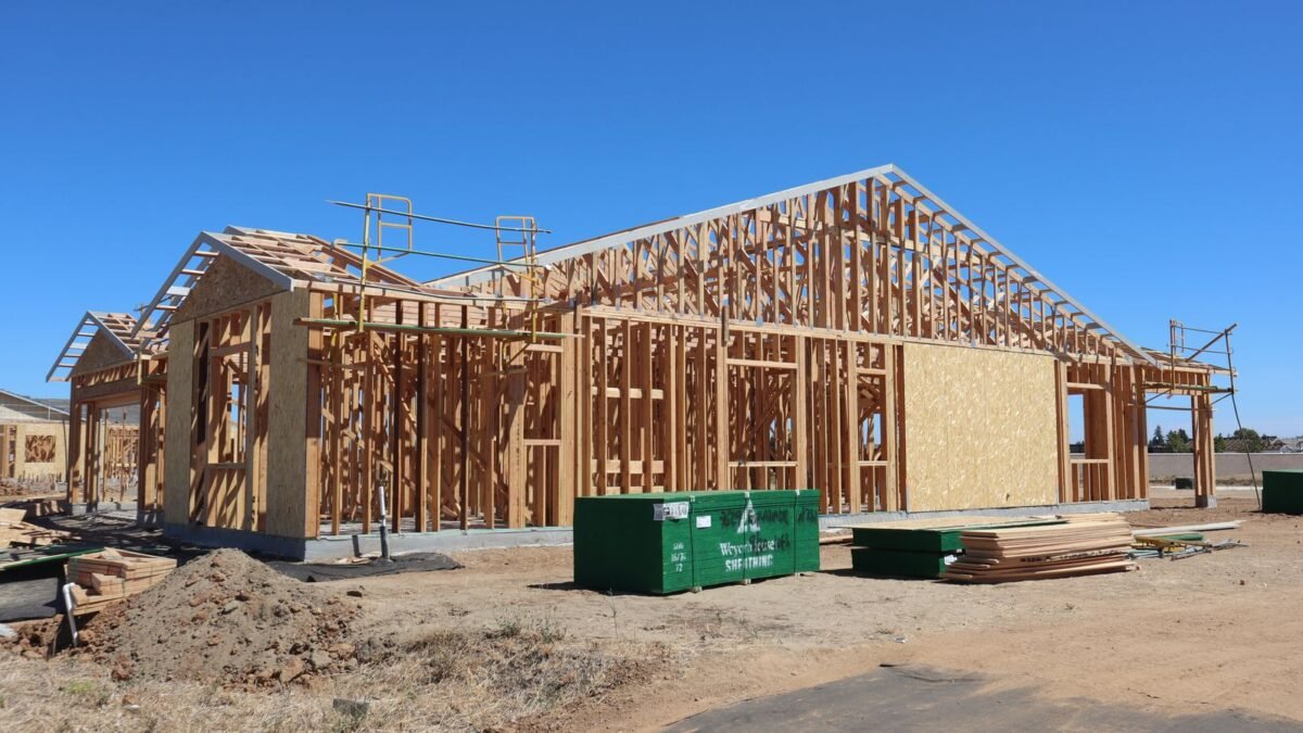 Wooden house frame construction under clear blue sky, sunny day, illustrating best water softener for new construction