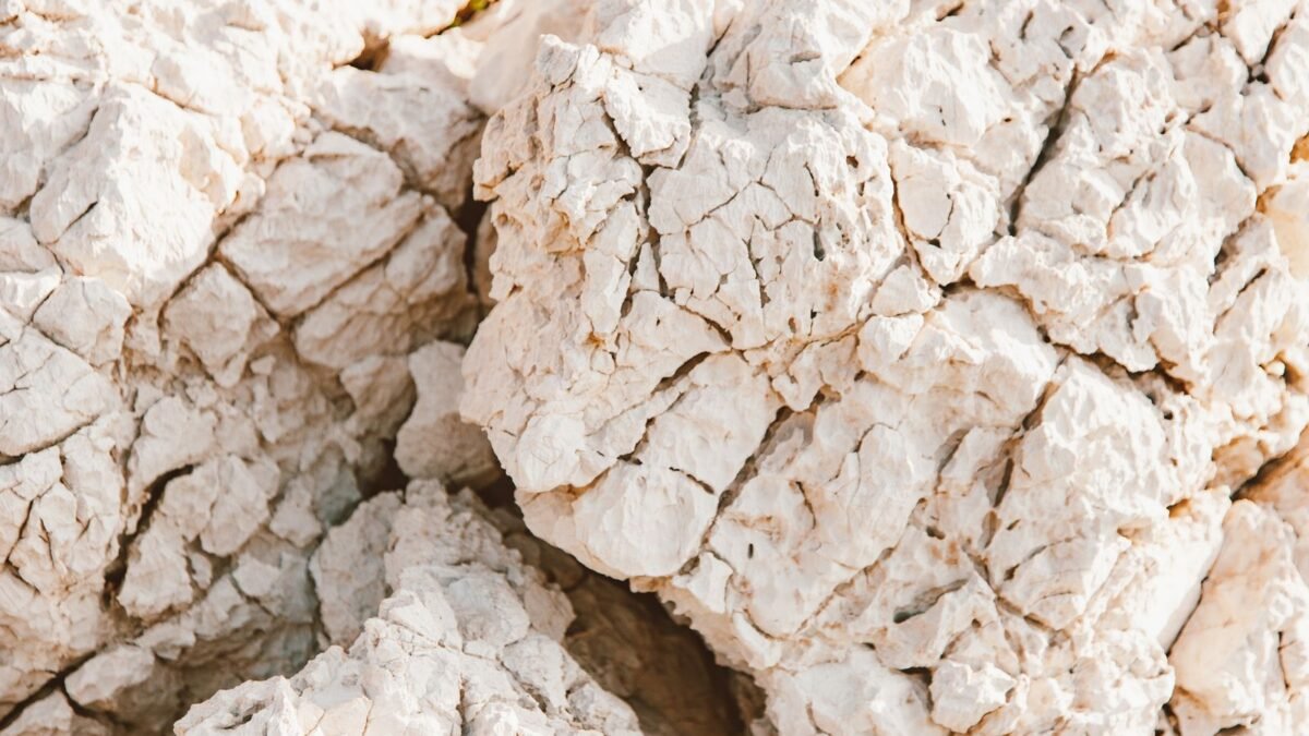 A close-up of textured white rocks with natural cracks, captured outdoors in bright sunlight, illustrating best water softener for very hard water