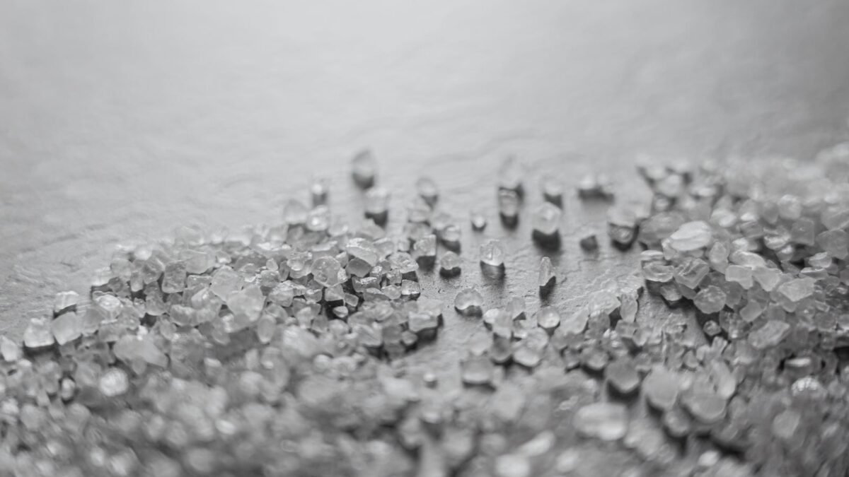 Detailed macro shot of scattered rock salt crystals with soft focus, creating a textured abstra, illustrating best water softener salt