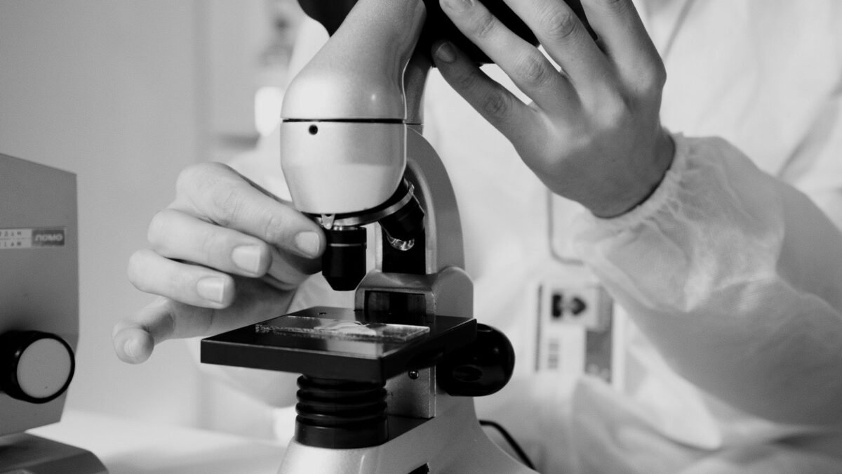 A scientist in a lab coat using a microscope for research in a laboratory setting, illustrating best well water filter for bacteria