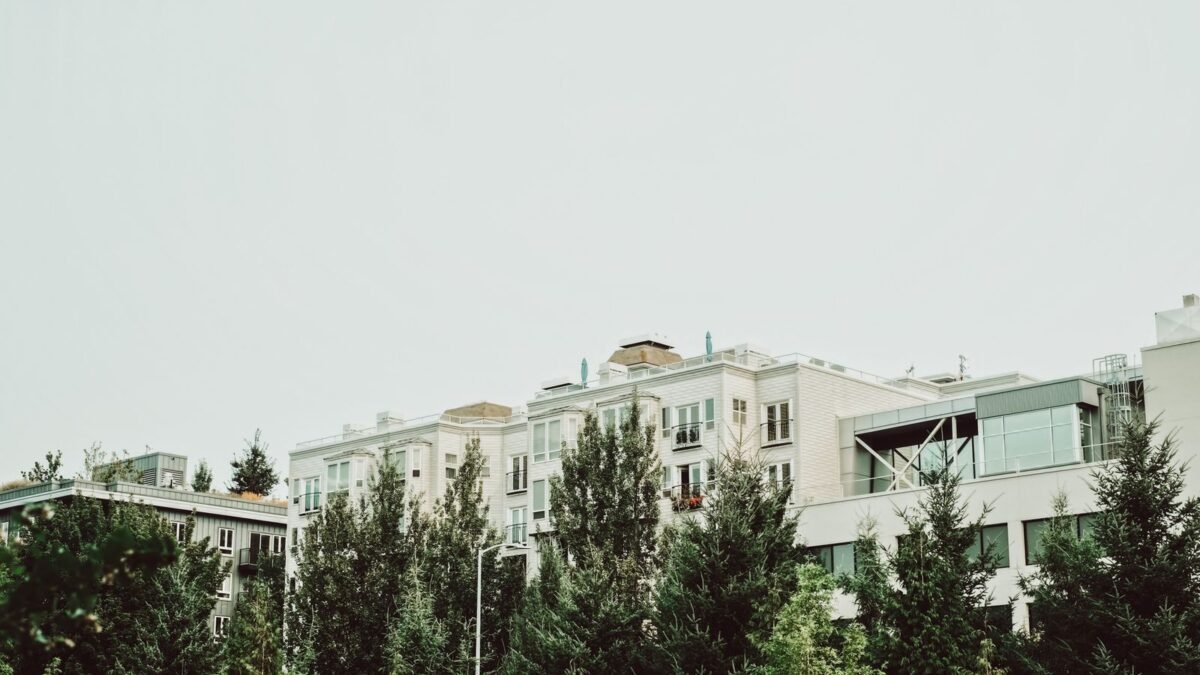 A view of modern apartment buildings surrounded by lush trees in an urban area, illustrating best whole house water filter for city water