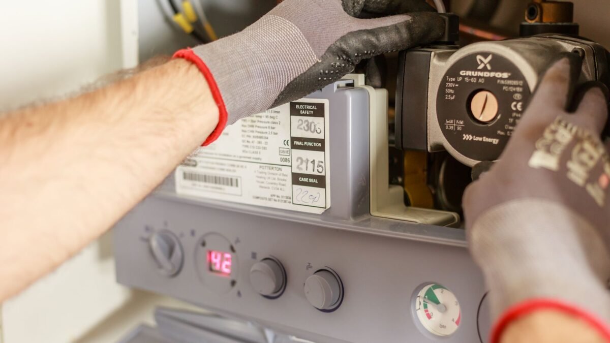 Close-up of hands adjusting a boiler system with precise instrumentation, showing maintenance w, illustrating culligan vs hague