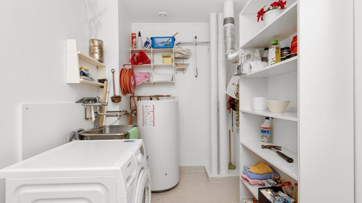 Clean and organized home laundry room with washing machine, shelves, and water heater, illustrating durawater water softener review