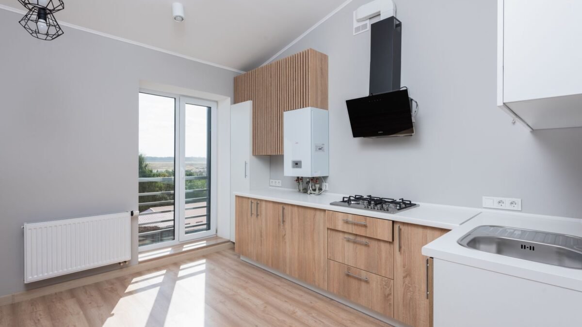Stylish empty kitchen with wooden cabinets and large windows, illustrating ge vs morton water softener