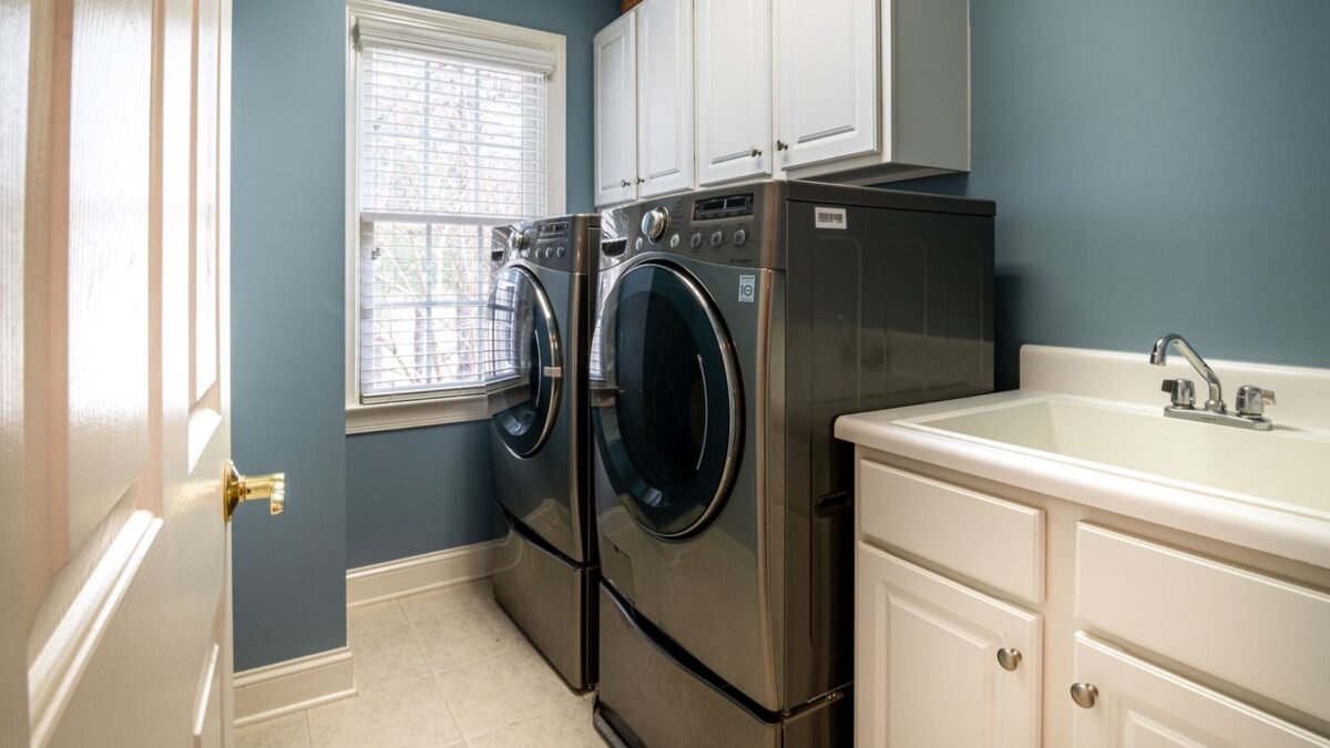 A clean, organized laundry room featuring modern appliances and ample storage, illustrating kenmore vs whirlpool water softener