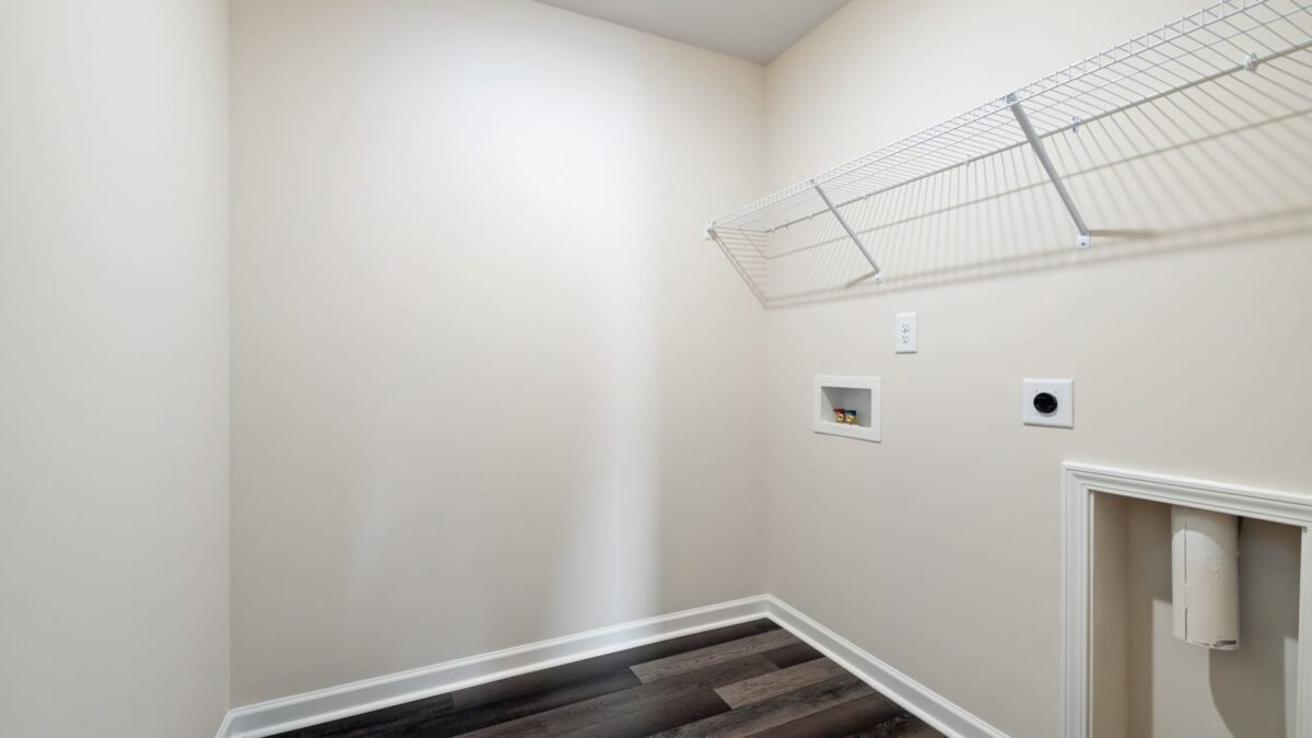 Bright and empty laundry space with wooden flooring and wire shelving, illustrating pentair vs culligan water softener