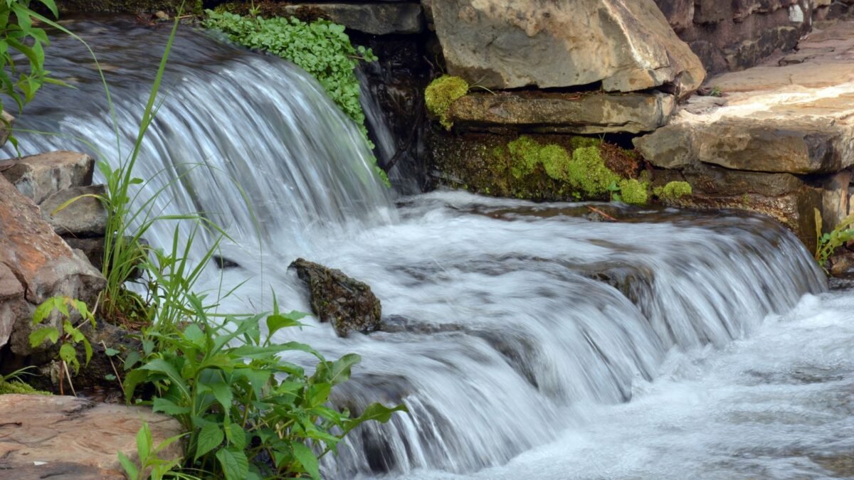 Peaceful waterfall cascading over rocks surrounded by lush greenery outdoors, illustrating softpro vs springwell