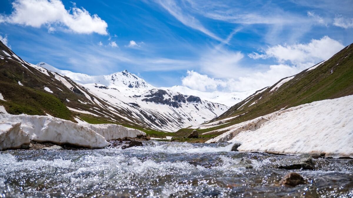 Scenic view of snowcapped mountains and flowing river in Livigno, Italy under a vibrant blue sk, illustrating springwell futuresoft vs pelican natursoft